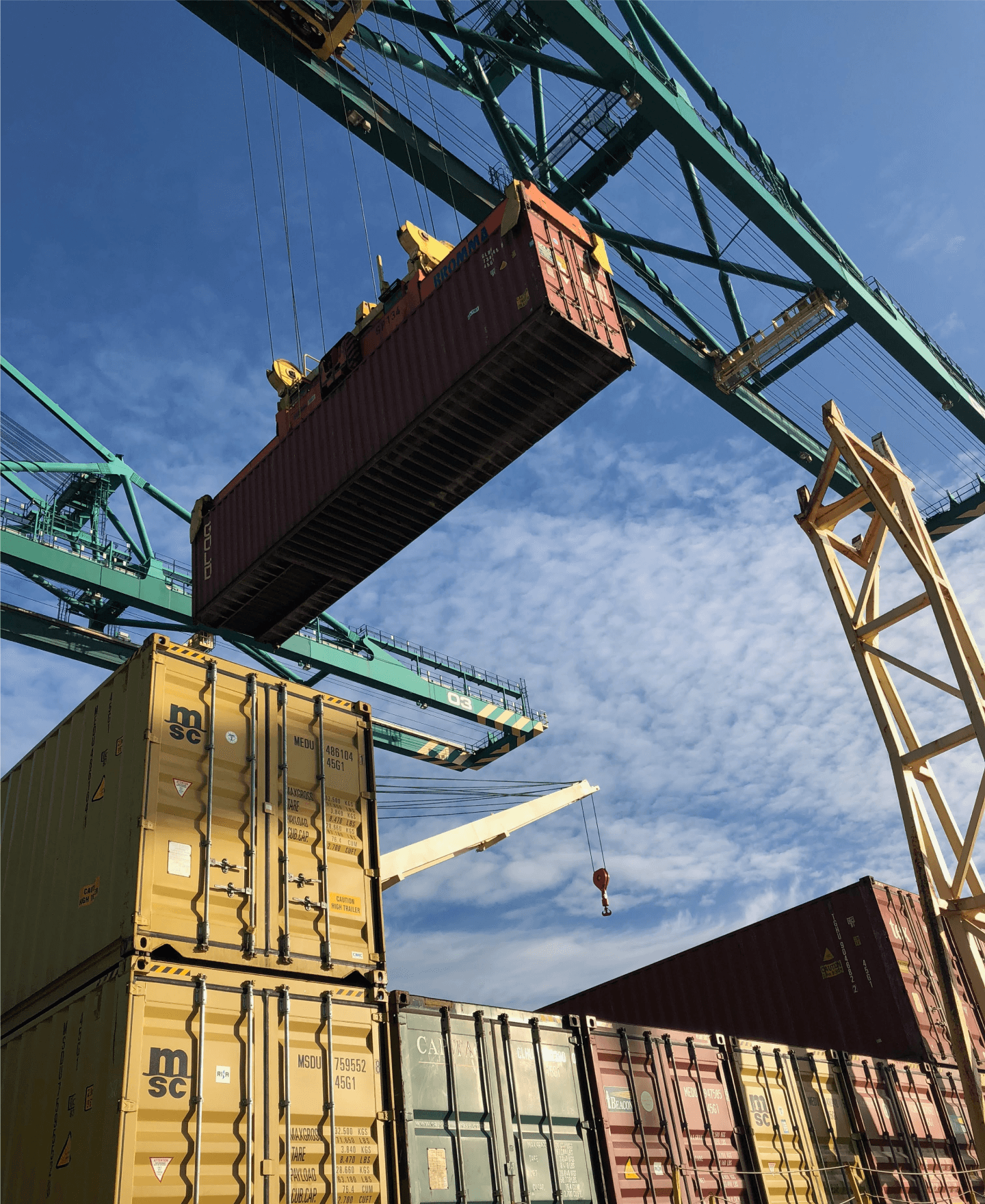 harbor view of a crane lifting a container.